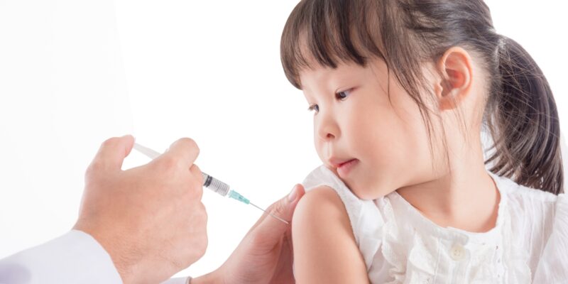 child getting a vaccine shot in the shoulder