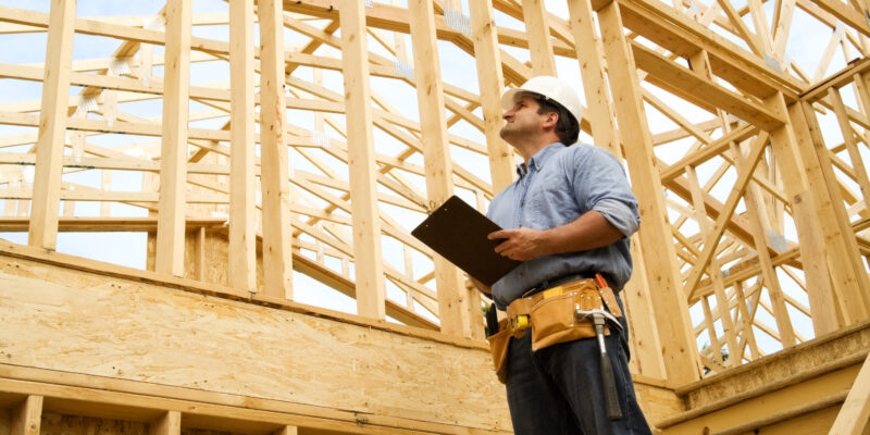 Contractor inspects framed home build