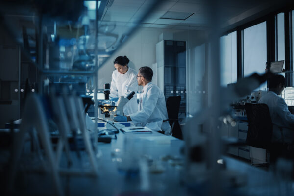 Modern,Medical,Research,Laboratory:,Two,Scientists,Working,,Using,Digital,Tablet,