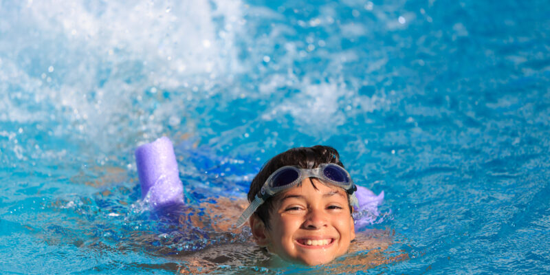 Happy kid swimming in pool