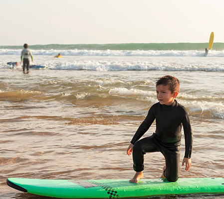 niños surfeando en la playa