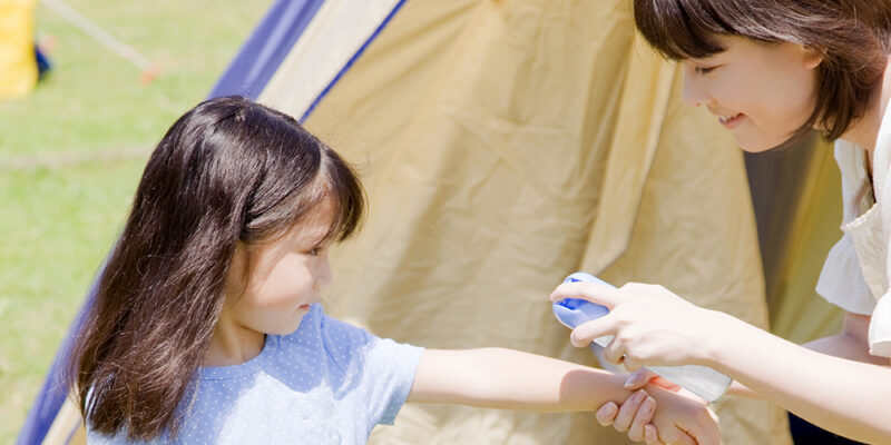 rociando repelente de insectos en un niño