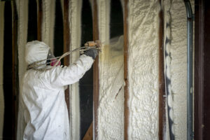person spraying insulation foam into wall