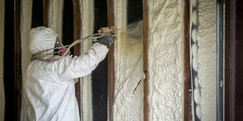 persona rociando espuma aislante en una pared