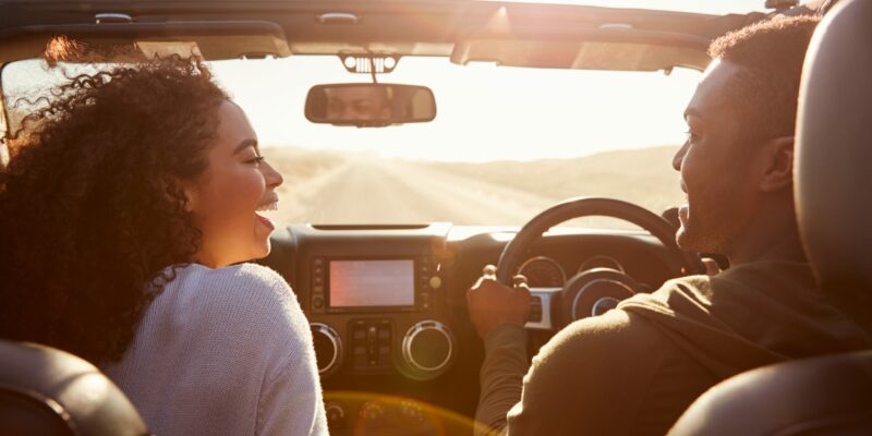 happy couple driving in convertible