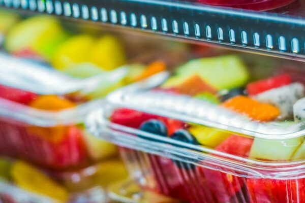 contenedores de plástico llenos de fruta en una tienda de comestibles