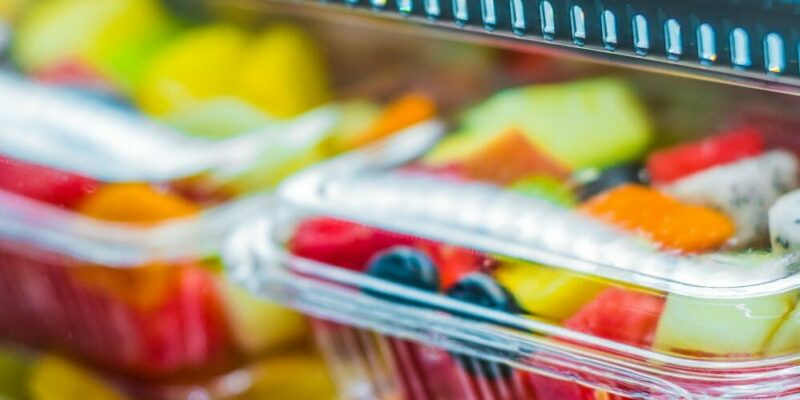 contenedores de plástico llenos de fruta en una tienda de comestibles