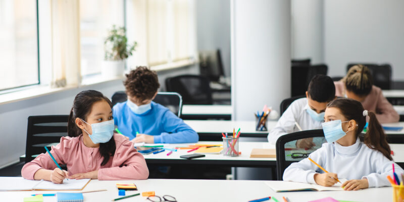 estudiantes usando mascarillas en un salón de clases