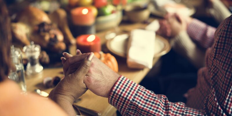 personas sentadas a la mesa en la cena de Acción de Gracias