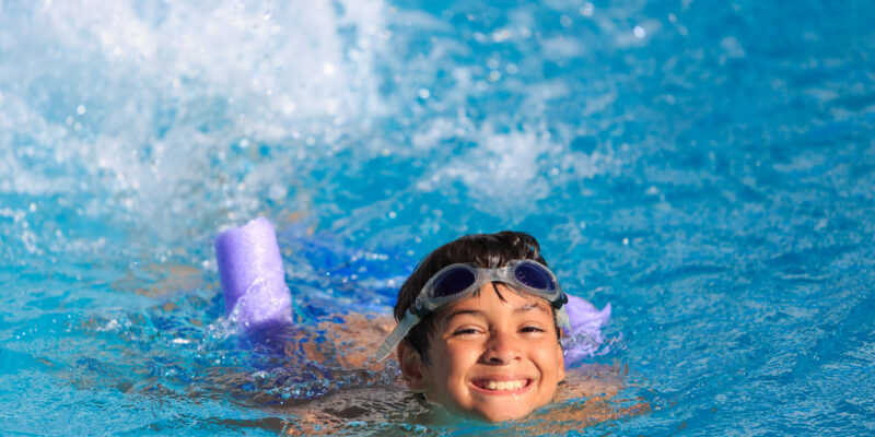 Niño feliz nadando en una piscina