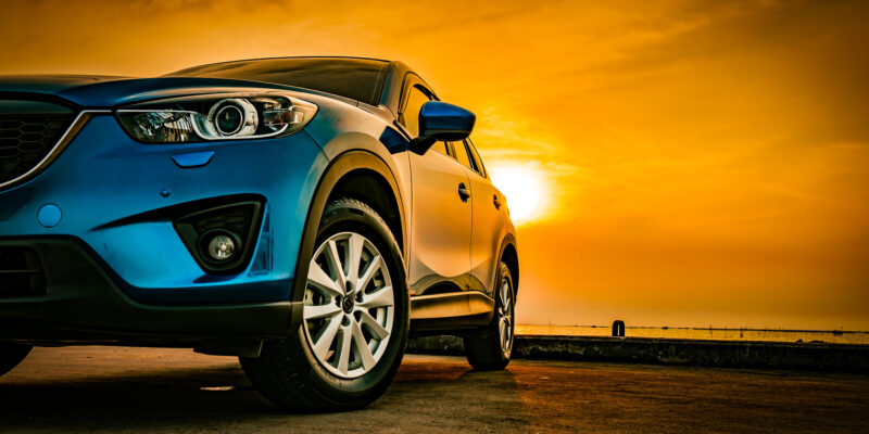 blue car at beach at sunset